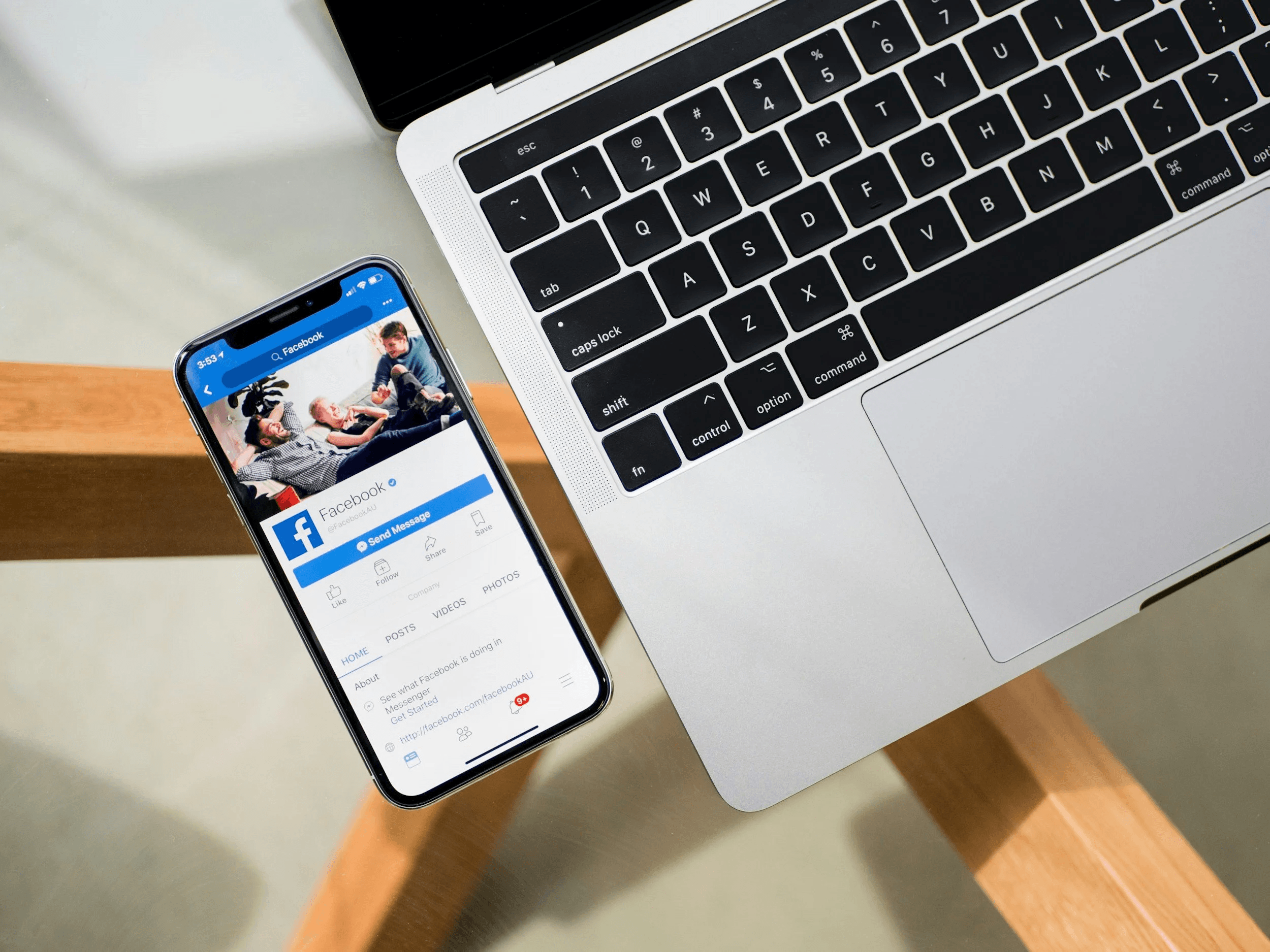 A smartphone displaying a social media page beside a laptop